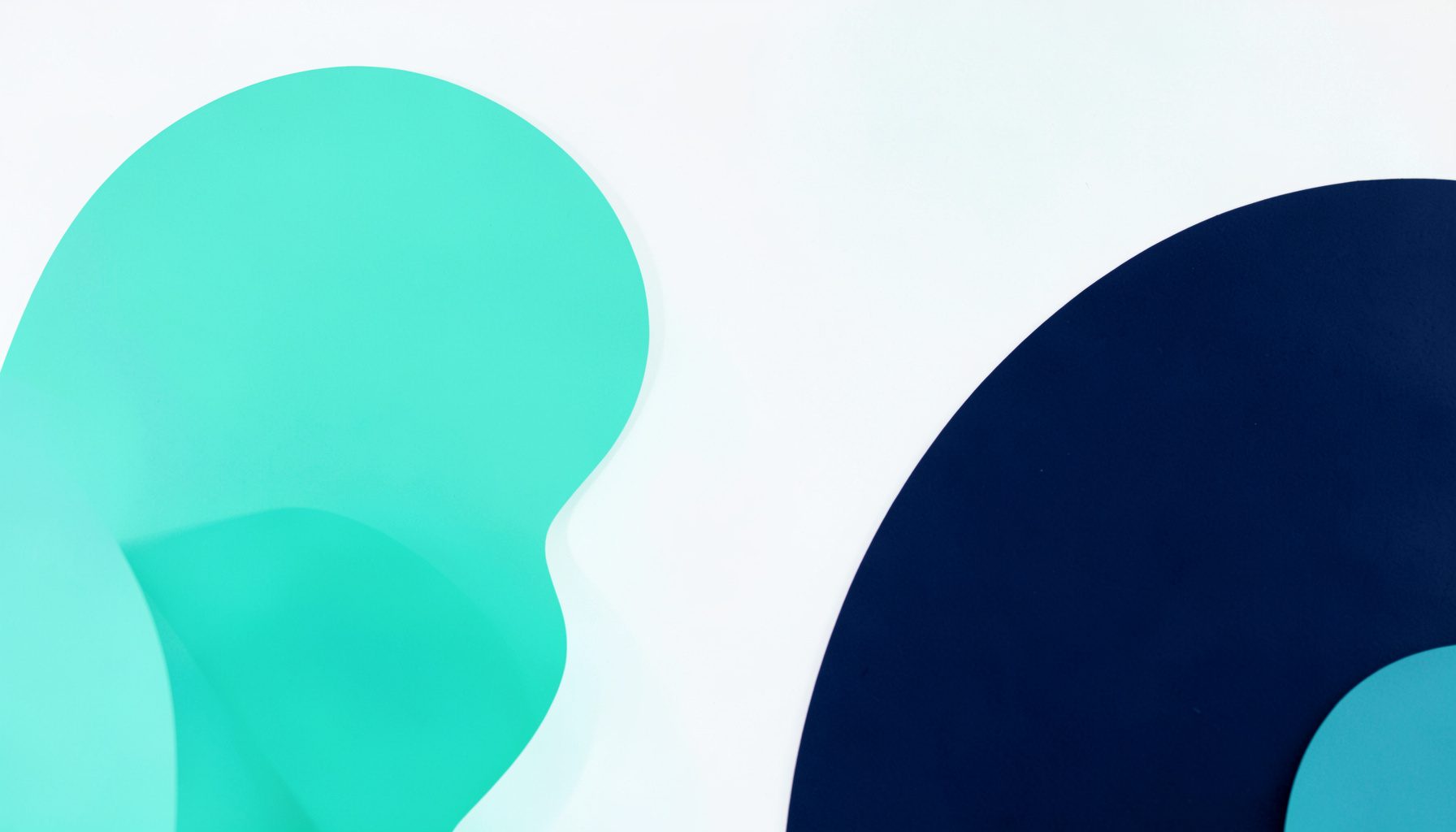A soft mint and navy abstract studio photograph on a seamless light backdrop, featuring rounded geometric shapes in fresh teal and deep navy against a clean white background.